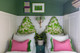 Twin beds with green patterned headboards and Pink cushions with ombre fringe green trim edges.